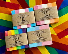 Load image into Gallery viewer, Four soap bars with 'Love is Love' packaging on a colorful pride flag background