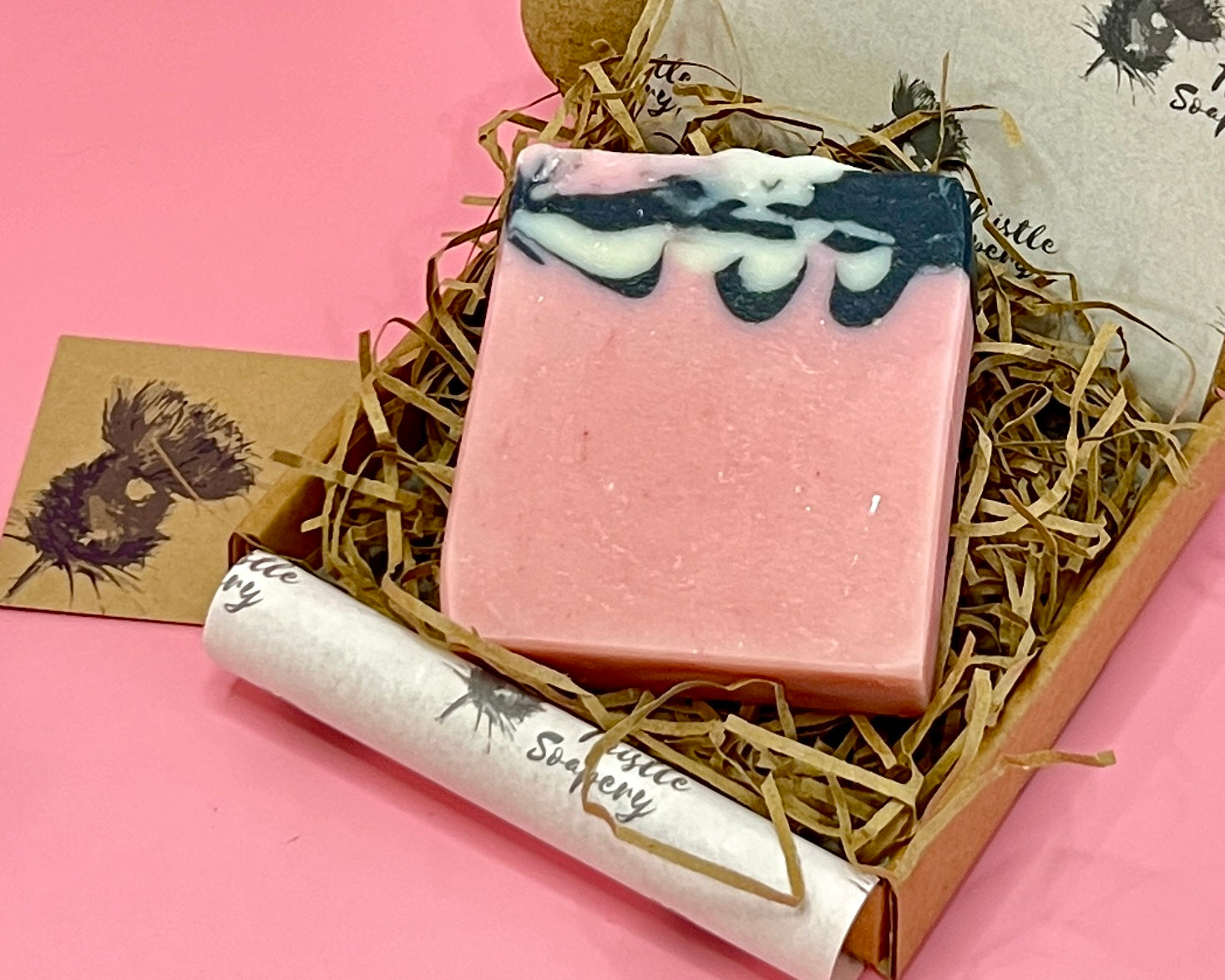 Pink soap with a black and white swirled layer presented in a gift box 