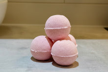 Load image into Gallery viewer, Pale pinky red Spicy Raspberry bath bombs stacked on a countertop 
