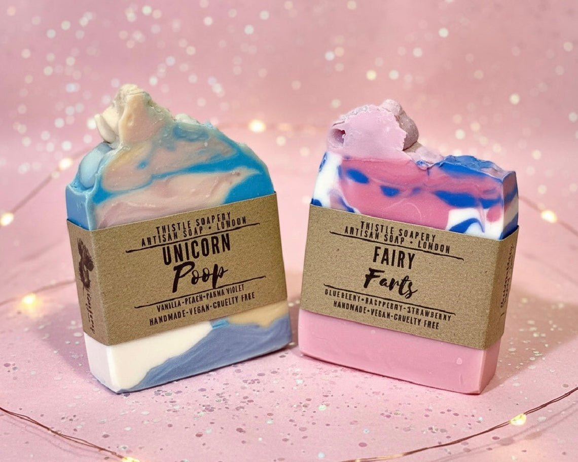 Two colorful soap bars with decorative packaging on a sparkling background