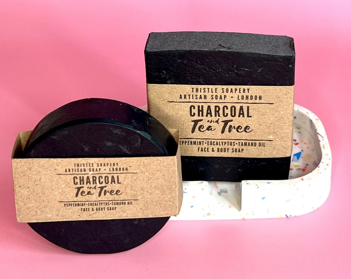 Charcoal and tea tree facial soap bars for oily or blemish prone skin on pink background