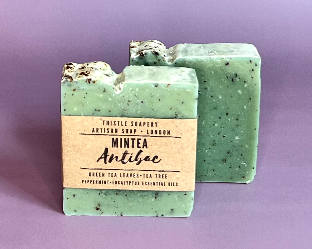 Green mintea soap with green tea and essential oils on purple background 
